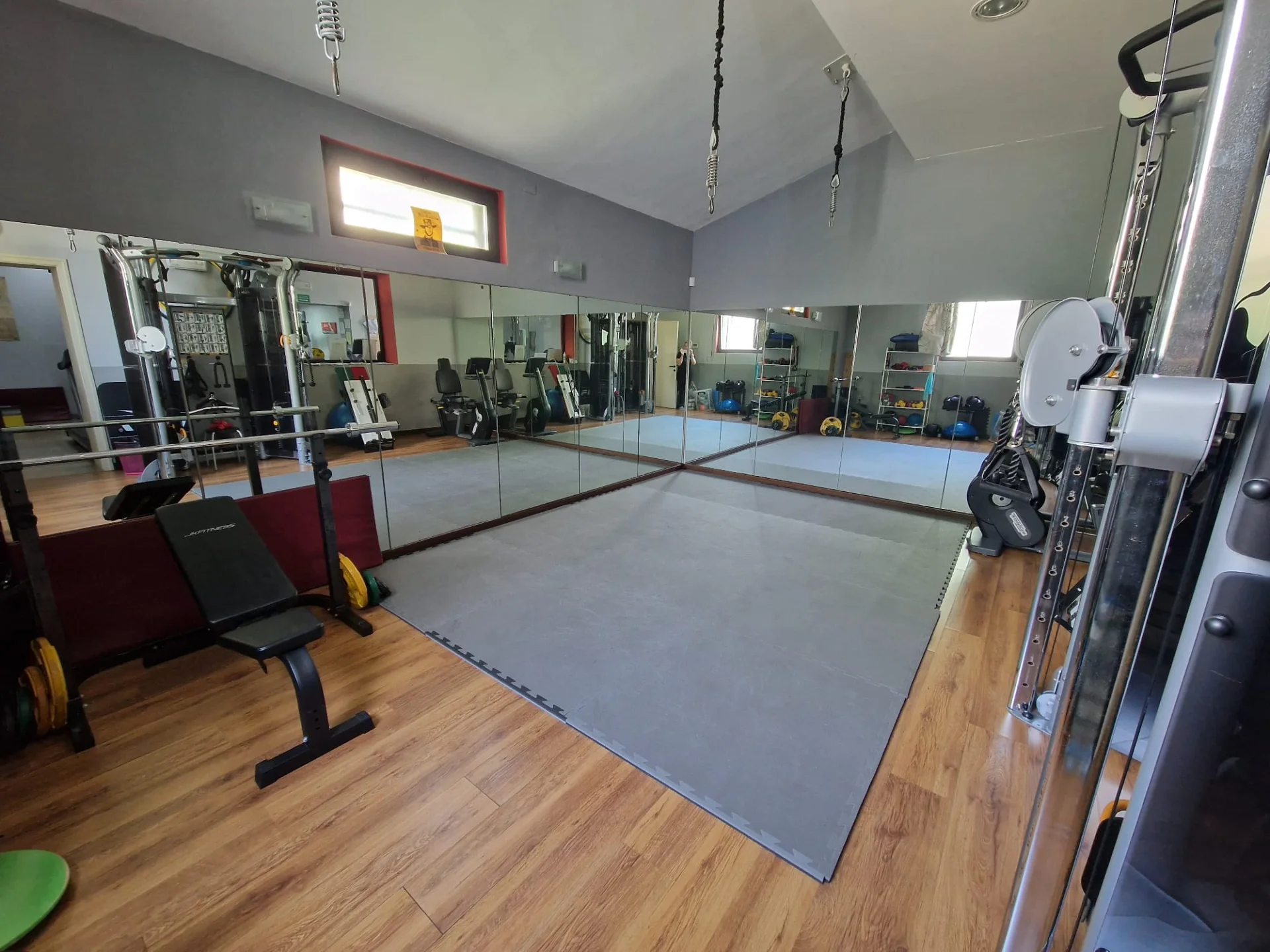 Sala attrezzi per area personal con tappeto in gomma e specchi alle pareti